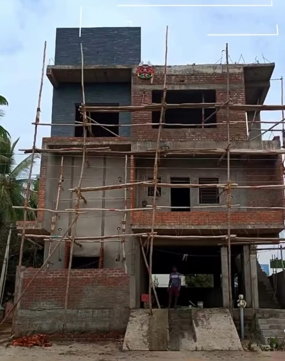 A multi-storey building mid-finish, scaffold still in place.